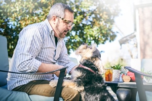 Dog and Man playing at patio table outdoors
